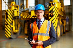 Supply chain manager holding an iPad and wearing an orange high-visibility vest